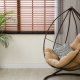Comfortable swing chair with pillows in room interior