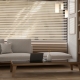 A cozy, contemporary minimalist living room features a large sofa and a laptop on a coffee table.