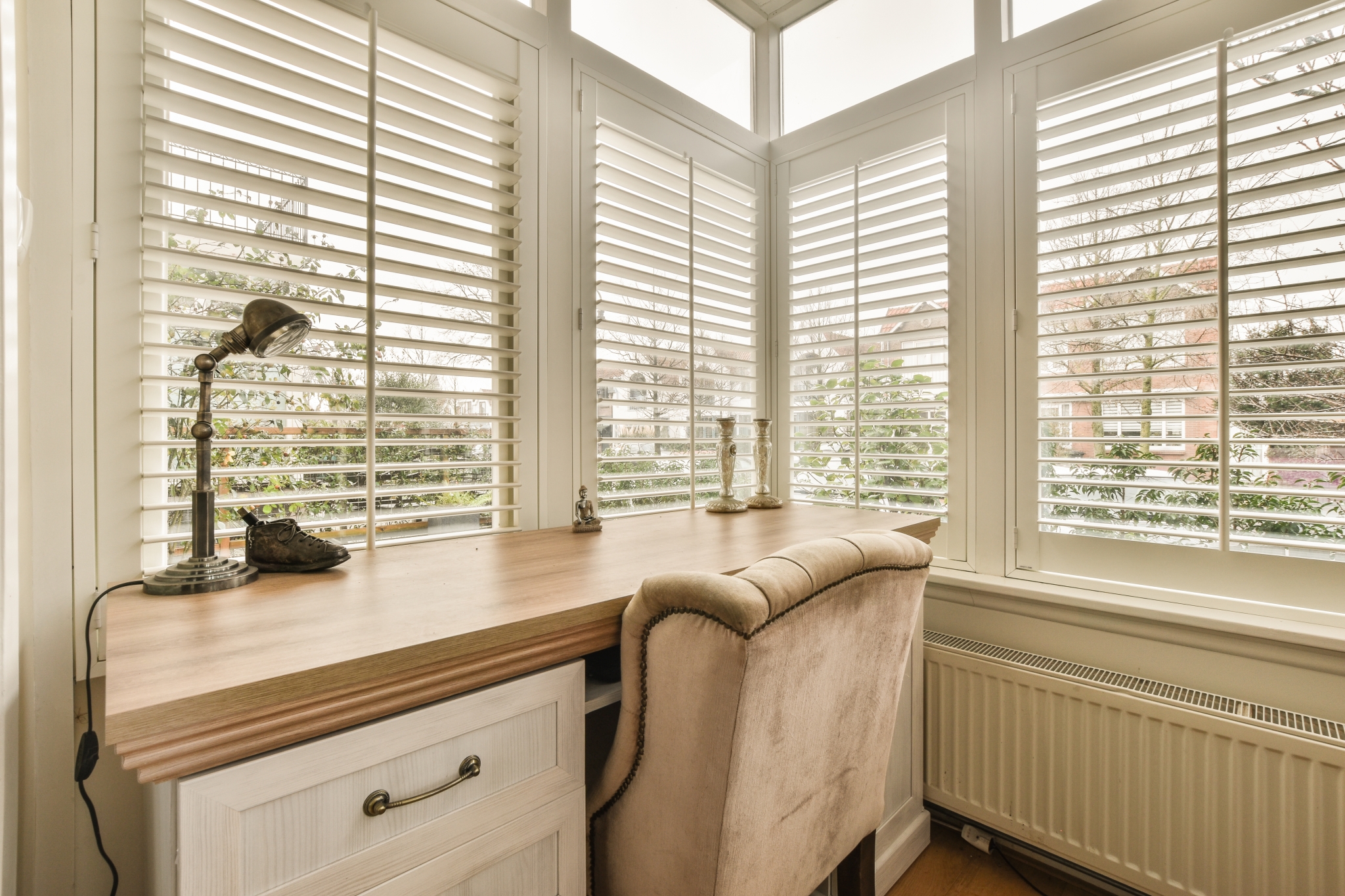 a home office with a large window and a chair