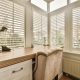 a home office with a large window and a chair